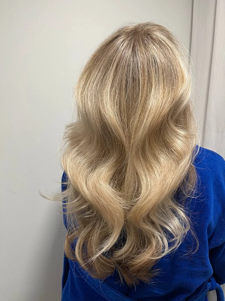 Soft blonde balayage with bouncy waves by Liza G.
